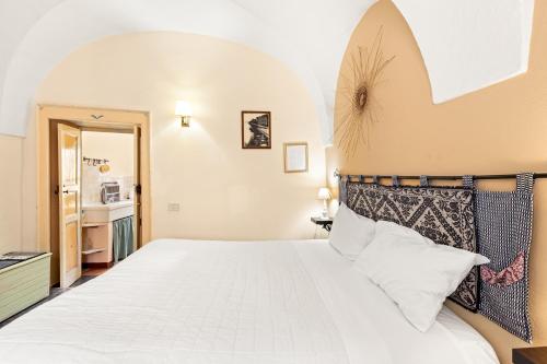 a bedroom with a large white bed in a room at Romeo e Giulietta Rooms in Bosa