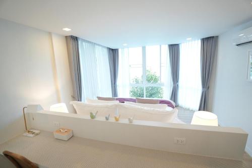 a bedroom with a large white bed with a window at P8 Cliff House Stunning Seaview in Ban Ko Kok