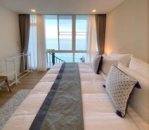 a large bed in a room with a large window at P8 Cliff House Stunning Seaview in Ban Ko Kok