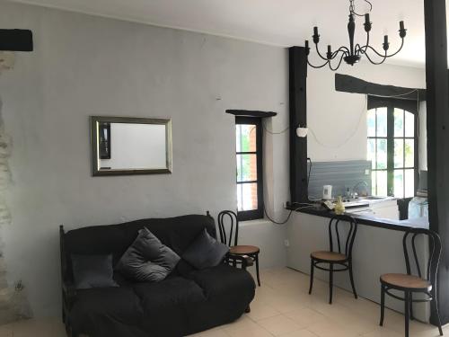 a living room with a couch and a kitchen at Le Gite Amical des Chiens in Penne-dʼAgenais
