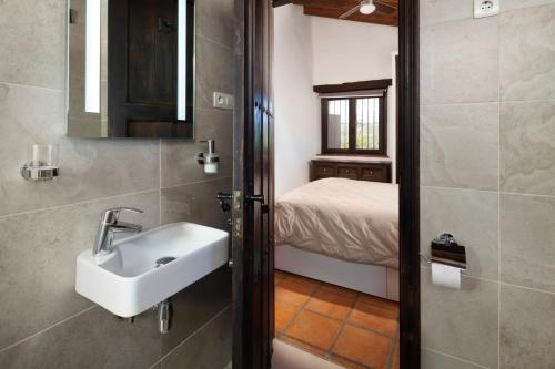 a bathroom with a sink and a bed in a room at Finca Mojito in Cómpeta