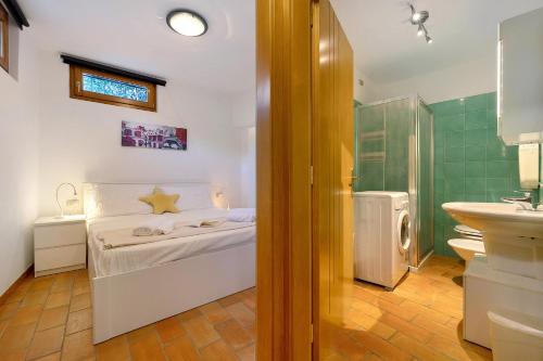 a bathroom with a bed and a sink in a room at Villa G By Immobilux in Nago-Torbole