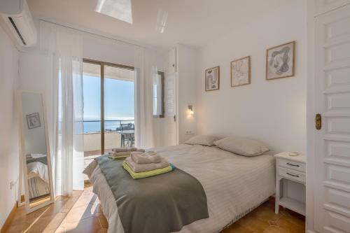 a bedroom with a bed with a view of the ocean at Casa Romantica in Salobreña