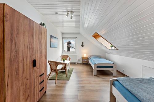 a attic bedroom with a bed and a bed and a desk at Zwischen den Wellen in Oldenburg in Holstein