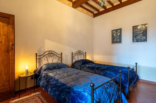 a bedroom with two beds with blue sheets at Palazzo Cofani in Arezzo