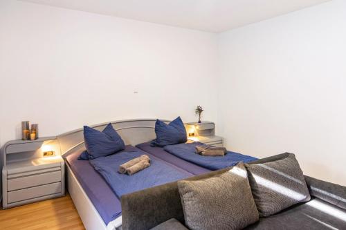 a bedroom with a bed with blue sheets and a couch at Zum weißen Roß in Hausen