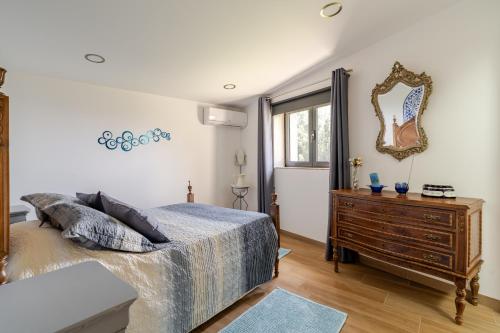 a bedroom with a bed and a dresser and a mirror at Casa Real De Cima in Fervença