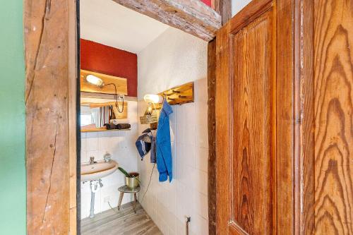 a bathroom with a sink and a wooden door at Fuchsbau In Der Ktv in Rostock