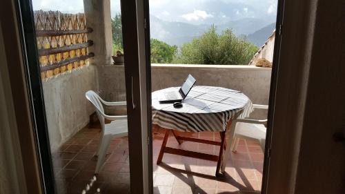 フィナーレ・リーグレにあるCollina e Mareのテーブルと椅子、バルコニー(ノートパソコン付)
