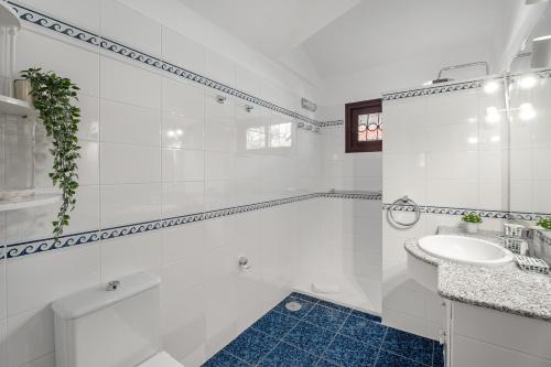 a white bathroom with a sink and a tub at Villa del Mar Palm Mar in Palm-Mar