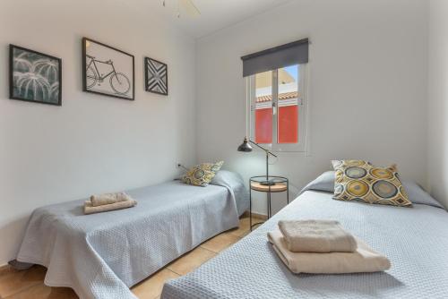 two twin beds in a white room with a window at Villa Atlantic Ocean Private Pool in Corralejo