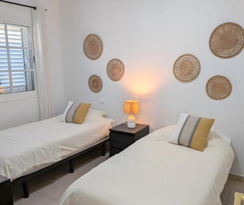 a bedroom with two beds and a lamp on a table at Sunset Villa Meloneras in Maspalomas