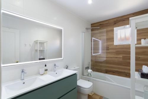 a bathroom with a sink and a toilet and a mirror at Sunset Villa Meloneras in Maspalomas