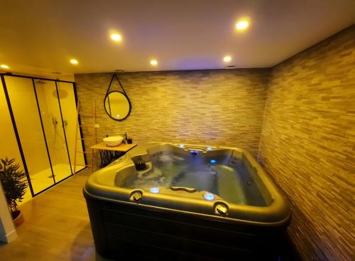 a large bathroom with a tub in a room at La Folie Romantique, Avec Spa in Sublaines
