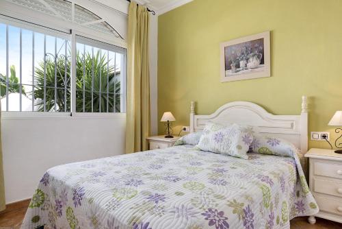 a bedroom with a bed and a window at Chalet Fuente3 piscina común famila in Conil de la Frontera