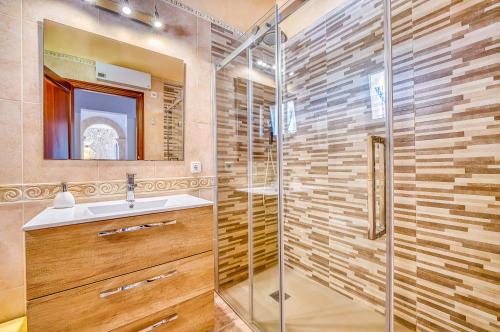 a bathroom with a glass shower and a sink at Las Naranjas in Muro