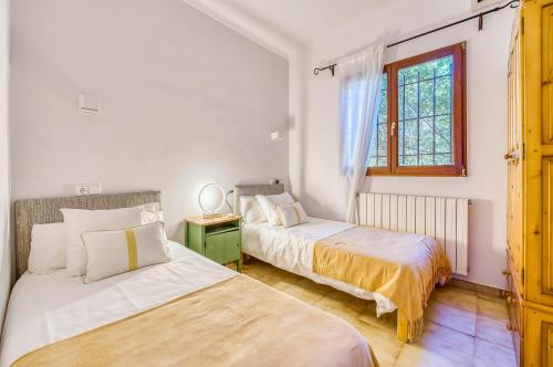 a bedroom with two beds and a window at Las Naranjas in Muro