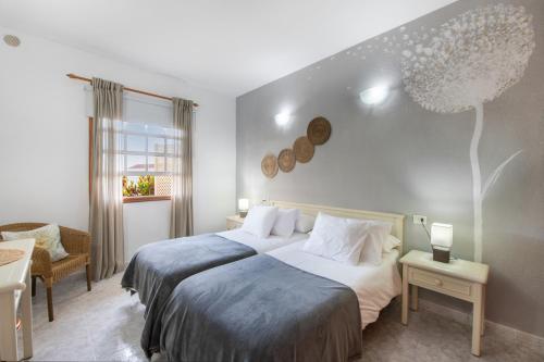 a bedroom with a bed and a chair and a window at Viento de Sal in Mazo