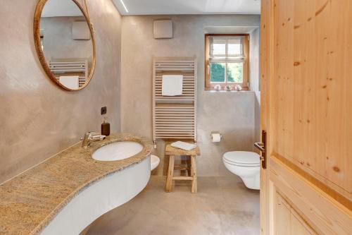 a bathroom with a sink and a toilet and a mirror at Chalet Sonne - Livigno in Livigno