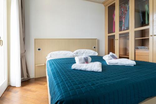 a bedroom with a green bed with white pillows at Aa Apartments La Gioconda in Salò