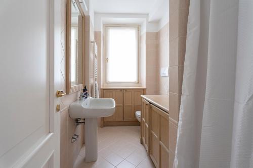 a bathroom with a sink and a toilet and a window at Aa Apartments La Gioconda in Salò