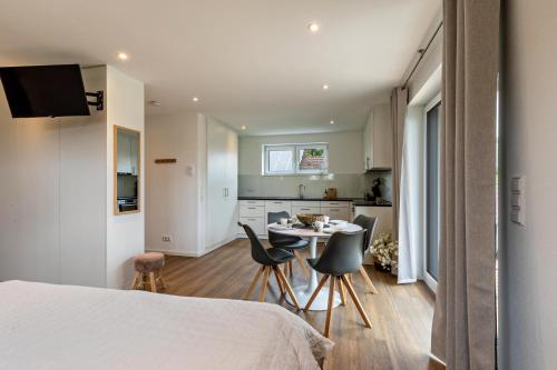 a bedroom with a bed and a table and chairs at Fewo Parkside S4 - 8Min Legoland in Günzburg
