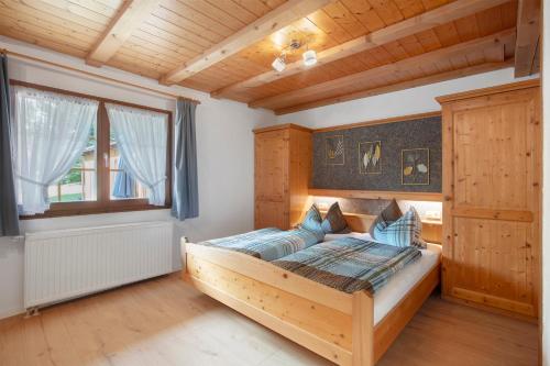 a bedroom with a wooden bed and a window at Gästehaus Klingele in Todtmoos