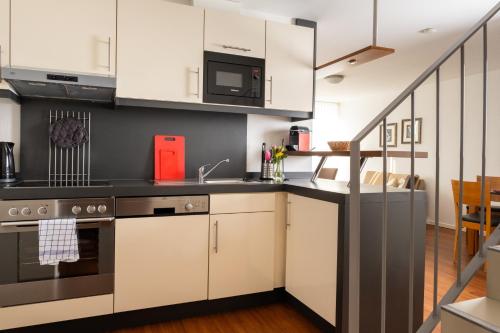 a kitchen with white cabinets and a sink at Ferienhaus Jümmers - Pidder in Horumersiel