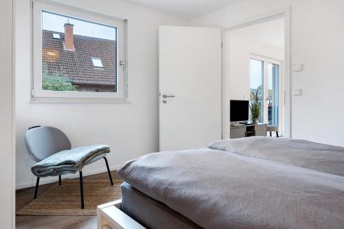 a bedroom with a bed and a chair and a window at Unterkunft für Messen und Freizeit in Hemmingen