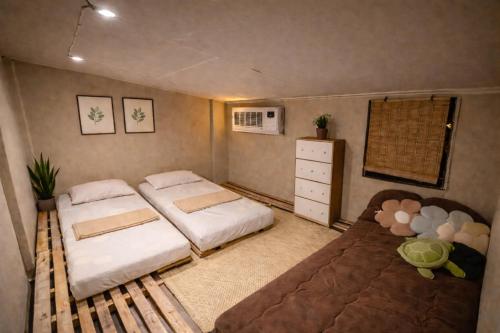 a small bedroom with two beds and a couch at The Stoked Hideout - Bagasbas Beach in Daet