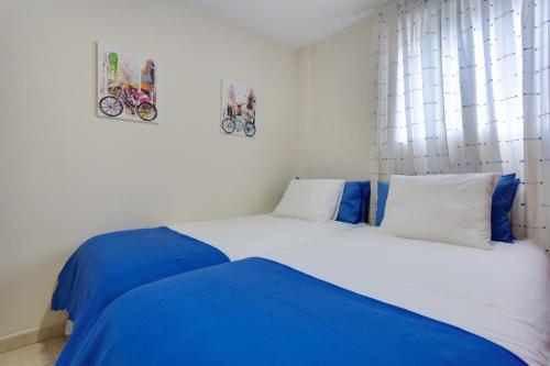 two beds in a bedroom with blue and white at Luxury Ático Plaza in Playa de San Juan