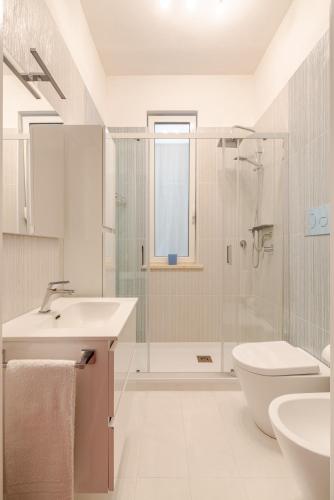 a bathroom with a toilet sink and a shower at Kina House in Marsala
