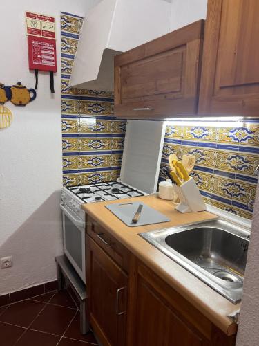 a kitchen with a sink and a stove at Casa Dade in Tavira