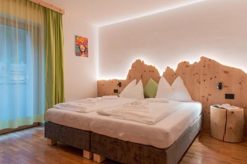 a bedroom with a bed with a wooden headboard at Dolomites Apartment Christian in Ortisei