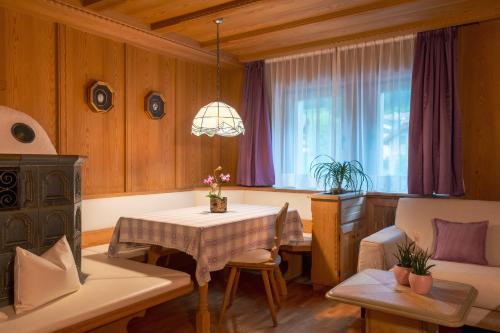 a living room with a table and a couch at Dolomites Apartment Christian in Ortisei