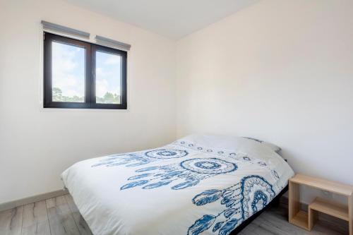 a bed in a white room with a window at Ty Kervignon 1 - 2,5kms de la plage in Plobannalec-Lesconil