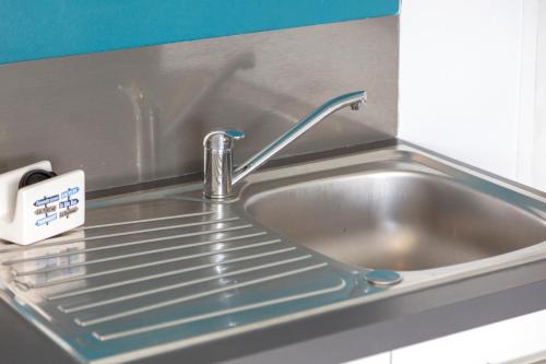 a sink with a faucet in a kitchen at Ty Kervignon 1 - 2,5kms de la plage in Plobannalec-Lesconil