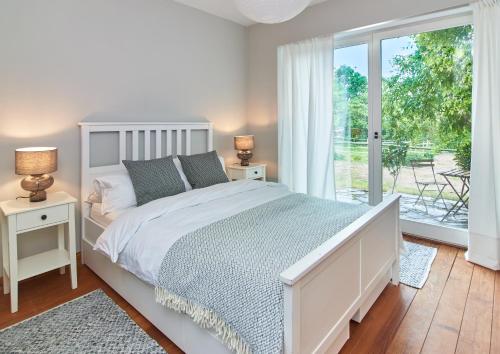 a bedroom with a white bed and a sliding glass door at Künstlerwohnung im Naturpark in Meezen