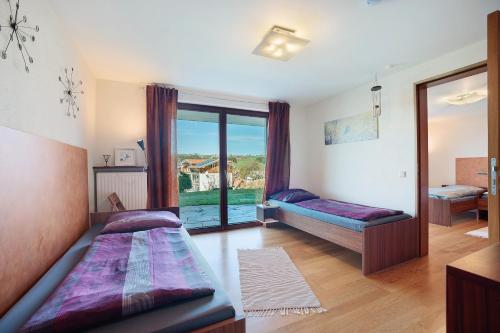 a bedroom with two beds and a large window at Freiraum in Weiler-Simmerberg