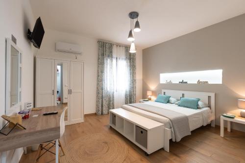 a bedroom with a large bed and a desk at Civico17 in Santa Ninfa
