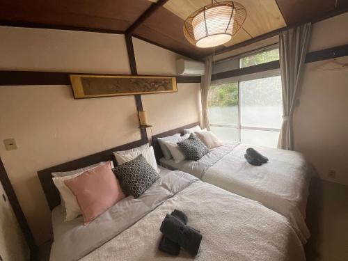 a bedroom with two beds and a window at 伊勢ブルーヴィラ本館と離れ in Ise