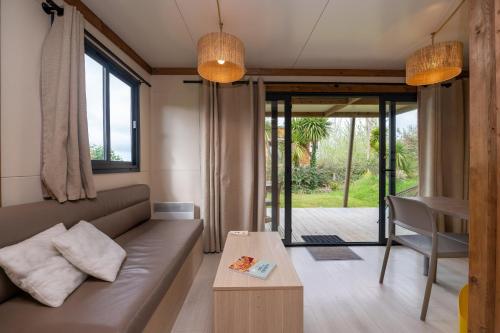 a living room with a couch and a table at Chalet 20m2 - Ile Vierge in Plouhinec