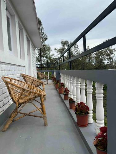 a porch with chairs and potted plants on a house at Green Valley in Kolakambe
