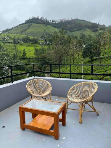 two chairs and a coffee table on a balcony at Green Valley in Kolakambe
