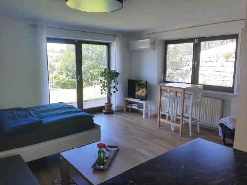 a living room with a bed and a table at Am Dorfweiher in Tettnang