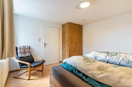 a bedroom with a bed and a chair at Fewo Straub in Freudenstadt