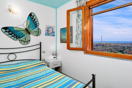 a bedroom with a butterfly clock and a window at Quadrilocale Le Colonne in Lu Lioni