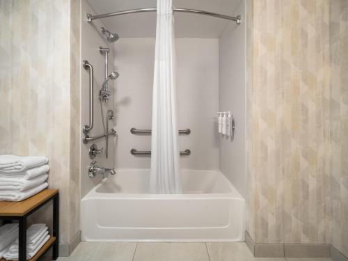 a bathtub with a shower curtain in a bathroom at Hampton Inn Warrenton, Va in Warrenton