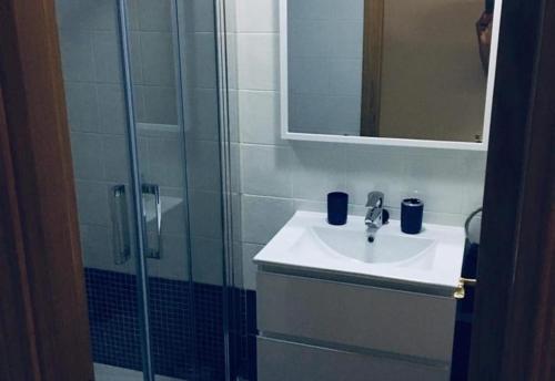 a bathroom with a sink and a shower with a mirror at Lux Apartm Beauvivir in Torre del Mar