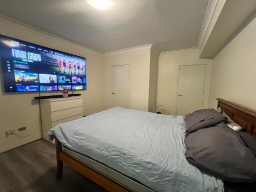 a bedroom with a bed and a large screen at The Castle in Castle Hill